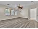 Spacious bedroom with wood-look flooring, ceiling fan, and multiple windows at 1670 Boundary Peak Way, Las Vegas, NV 89135