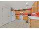 Kitchen boasts wood cabinets, white appliances, and tiled floor at 6058 Ambleshire Ave, Las Vegas, NV 89139