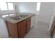 Kitchen island with double sink, dishwasher, and granite countertop at 8348 Stillhouse Ct, Las Vegas, NV 89113