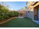 Landscaped backyard with artificial turf and a variety of plants at 10751 Centerville Bay Ct, Las Vegas, NV 89179