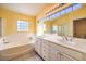 Bathroom offers a double vanity, soaking tub, and a window at 2683 Regency Cove Ct, Las Vegas, NV 89121