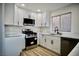 Modern kitchen with white cabinets, quartz countertops, and stainless steel appliances at 5746 Wind Dancer Dr, Las Vegas, NV 89118