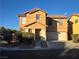 Two-story house with tan exterior, attached garage, and landscaping at 8335 Golden Amber St, Las Vegas, NV 89139