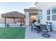 Relaxing backyard patio with dining table and thatch umbrella at 9598 Medway Towns Ave, Las Vegas, NV 89178