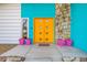 Bright yellow double front door with pink planters at 1589 Raindance Way, Las Vegas, NV 89169