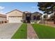 Single story home with brick walkway, two-car garage and landscaped lawn at 2374 Amana Dr, Henderson, NV 89044