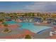 Outdoor community pool with blue umbrellas, lounge chairs, and mountain views at 2400 Wisconsin Dells Dr, Henderson, NV 89044