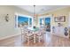 Charming dining area with a green table, white chairs, and large windows overlooking the outdoors at 2400 Wisconsin Dells Dr, Henderson, NV 89044