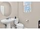 Small bathroom with pedestal sink, toilet and window at 3625 Modico Ln, Henderson, NV 89044