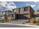 Two story house with brown exterior, paved driveway, and landscaping at 391 American Dipper St, Las Vegas, NV 89138