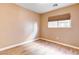 Well-lit bedroom featuring wood-look floors and window blinds at 6608 Wind Whisper St, Las Vegas, NV 89148