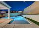 Stunning pool with built-in seating and nighttime lighting at 8967 Rolling Pietra St, Las Vegas, NV 89166