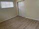 Empty bedroom with wood-look flooring, white trim, a window, and sliding closet doors at 1812 Ryan Ave, Las Vegas, NV 89101