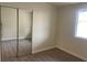 Empty bedroom with mirrored sliding closet doors, wood-look flooring, and a window at 1812 Ryan Ave, Las Vegas, NV 89101