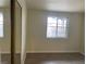 Bright, empty bedroom with wood-look flooring, a large window, and white trim at 1812 Ryan Ave, Las Vegas, NV 89101