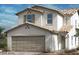 Two-story house with a beige exterior, neutral-toned garage door, and Spanish-style roof at 4175 Nopal Serrano Ave, Las Vegas, NV 89141