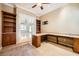 Home office with built-in wooden bookcases and French doors at 9833 Masterful Dr, Las Vegas, NV 89148