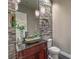 Elegant powder room with stone feature wall and modern sink at 10534 Riley Cove Ln, Las Vegas, NV 89135