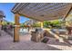 Outdoor kitchen with pergola, grill, and granite countertop at 10534 Riley Cove Ln, Las Vegas, NV 89135