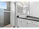 Modern bathroom with a white vanity, gray tile, and a walk-in shower at 133 S Buteo Woods Ln, Las Vegas, NV 89144