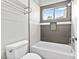 Clean bathroom with a bathtub, toilet and gray tile at 133 S Buteo Woods Ln, Las Vegas, NV 89144