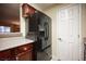 Kitchen with black refrigerator, dark wood cabinets, and granite countertops at 2451 N Rainbow Blvd # 2082, Las Vegas, NV 89108