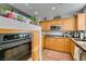 Kitchen with wooden cabinets, black appliances, and tile floor at 67 E Agate Ave # 202, Las Vegas, NV 89123