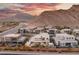 Aerial view of homes with mountain backdrop at sunset at 4024 Desert Trace Ct, Las Vegas, NV 89129