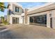 Modern home with glass garage doors and paved driveway at 4024 Desert Trace Ct, Las Vegas, NV 89129