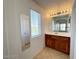 Bathroom with wood vanity, mirror, and window at 5087 Penryn Ct, Las Vegas, NV 89139