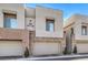 Tan two-story townhouses with attached garages and stone accents at 600 N Carriage Hill Dr # 1187, Las Vegas, NV 89138