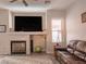 Living room with fireplace, large TV, and brown leather sectional sofa at 1774 Garden Ridge Ct, Henderson, NV 89012