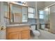 Bathroom with oak vanity, granite countertop, shower/tub combo, and frosted glass shower door at 2129 Colvin Run Dr, Henderson, NV 89052