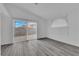 Living room with sliding glass doors leading to the backyard, wood-look flooring, and white walls at 2672 Rungsted St, Las Vegas, NV 89142