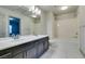 Double vanity bathroom with a bathtub and marble-look tile at 9887 Parador Cellars Ct, Las Vegas, NV 89141