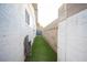 Narrow side yard with artificial turf and hose at 4250 Carolyn Dr, Las Vegas, NV 89103