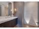 Modern bathroom featuring marble countertops, textured wall, and unique lighting at 32 Highland Cove Ln, Henderson, NV 89011