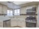 Bright kitchen with stainless steel appliances and white cabinets at 4200 Tolkien Ave, Las Vegas, NV 89115