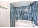 Modern bathroom with blue tiled shower and white tub at 4754 Monterrey Ave, Las Vegas, NV 89121