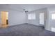 Bright bedroom with grey carpet, ceiling fan, and access to bath at 6288 Dolosonte St, Las Vegas, NV 89113