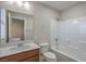 Simple bathroom with tub, toilet and vanity with wood cabinets at 6608 Fort William St, North Las Vegas, NV 89084