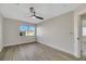 Bright bedroom with wood-look floors, ceiling fan, and window view at 293 Helmsdale Dr, Henderson, NV 89014