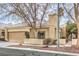 Tan single story house with a two-car garage and mature trees at 400 Mill Hollow Rd, Las Vegas, NV 89107