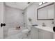 Modern bathroom featuring marble-look tile, gray vanity, and a shower/tub combo at 728 Marina Dr, Boulder City, NV 89005