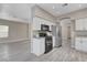 Modern kitchen with white cabinets, black appliances, and wood-look flooring at 8300 La Strada Ave, Las Vegas, NV 89129