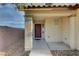 Covered front entry with a brown door, concrete walkway, and gravel landscaping at 10353 Cherokee Corner Ave, Las Vegas, NV 89129