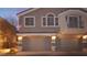 Two-story home exterior with a two-car garage and balcony at dusk at 10643 Petricola St # 103, Las Vegas, NV 89183