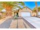 One-story house featuring a white garage door and palm trees at 227 Gray Granite Ave, Las Vegas, NV 89123