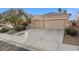 Tan house with a two-car garage and desert landscaping at 3509 Mastercraft Ave, North Las Vegas, NV 89031