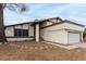 Two-story house with beige exterior, attached garage, and mature tree in front at 4417 De Forest St, Las Vegas, NV 89103